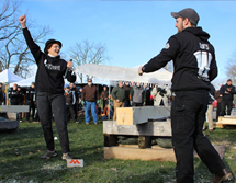 President Terenzio stands triumphantly with a Woodsmen club member after making a cut off the first log.