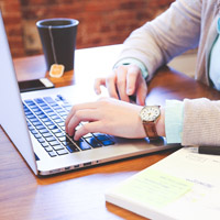 student working on laptop with finance notes